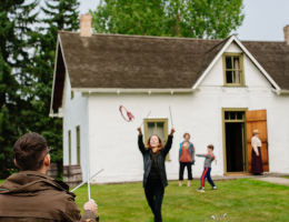 Visitors try some 1896 games and sports in front of the historic Clerk's Quarters